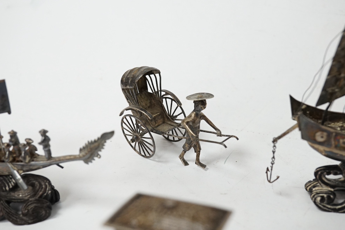 A Chinese white metal miniature model of a junk, length 11.2cm, on a wooden stand, a similar late 19th/early 20th century miniature filigree sedan chair and rickshaw by Kwan Wo and a Chinese white metal model of a boat w